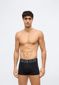 Svarta boxer briefs med en Calvin Klein-logotyp på midjebandet. Mjukt, stretchigt bomullstyg. Standardpassform med en medelhög design.