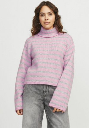 Un pull col roulé rayé rose et gris en matière tricotée douce, avec une coupe courte et des manches larges. Porté avec un jean gris.
