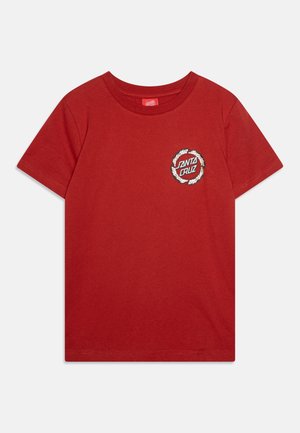 Červené bavlnené tričko s krátkymi rukávmi a okrúhlym výstrihom. Obsahuje okrúhly logotyp s nápisom "Santa Cruz" v čiernej a bielej farbe na hrudi.