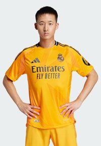 Maglia del portiere arancione con accenti neri, caratterizzata dal logo "Emirates Fly Better" e da linee diagonali come motivo. Realizzata in tessuto traspirante.