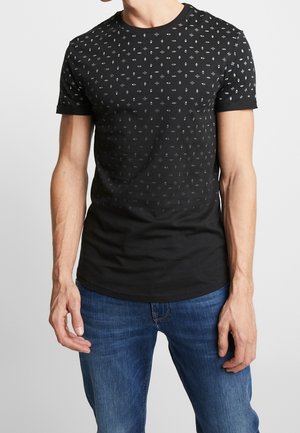 Zwart katoenen T-shirt met een ronde hals, voorzien van een fijn patroon van kleine grijze geometrische vormen over het hele kledingstuk. Korte mouwen en een aansluitend model.