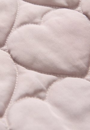 Vaatteetettu kangas pehmeässä vaaleanpunaisessa, jossa on sydäntaitto kuvio, joka sisältää teksturoituja kaartoja ja tasaisia alueita, korostaen yksityiskohtaista ompelua.