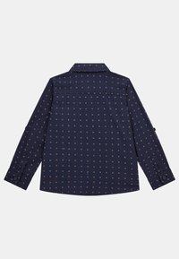 Camicia navy con maniche lunghe e colletto, caratterizzata da un motivo geometrico e polsini con bottoni. Tessuto dalla texture liscia.