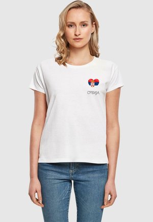 Hvit bomull T-skjorte med korte ermer, med et hjerte-design i rødt, blått og en krone, med ordet "Србија" i grått under.