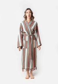 Robe a strisce nei colori crema, rosso, blu e verde, con maniche lunghe, cintura, due tasche frontali e orlo frangiato. Realizzata in tessuto morbido.