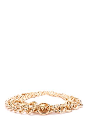 Guld kædearmbånd med sammenkædede led og en rund Michael Kors logo vedhæng i midten, på en hvid baggrund.