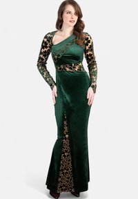 Grünes Samtkleid mit langen, floralen Spitzenärmeln, asymmetrischem Ausschnitt und goldenen Akzenten an der Taille und seitlichen Schlitzen. Elegantes und figurbetontes Design.