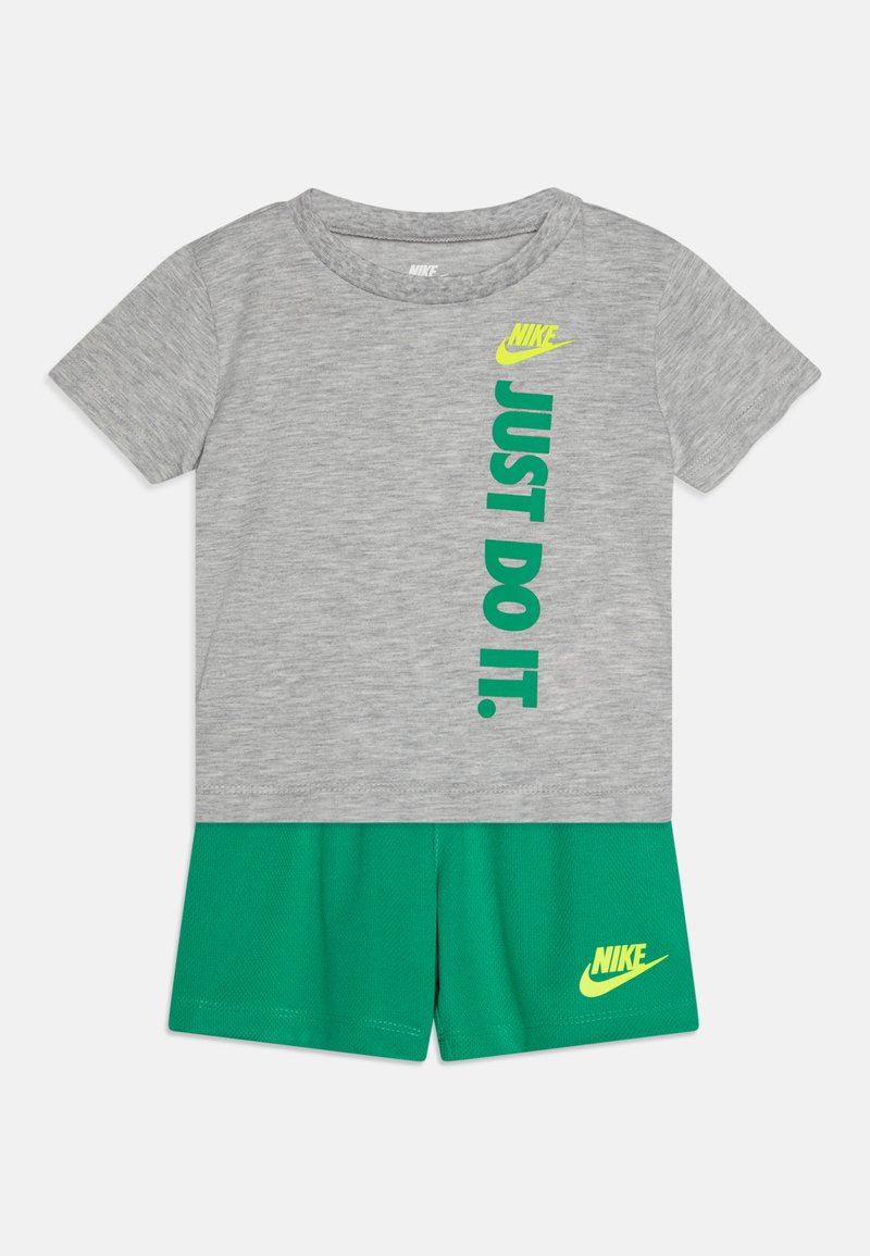 Gray t-shirt with "JUST DO IT." in green text, paired with green shorts featuring a yellow Nike logo. Soft fabric, short sleeves, and relaxed fit.