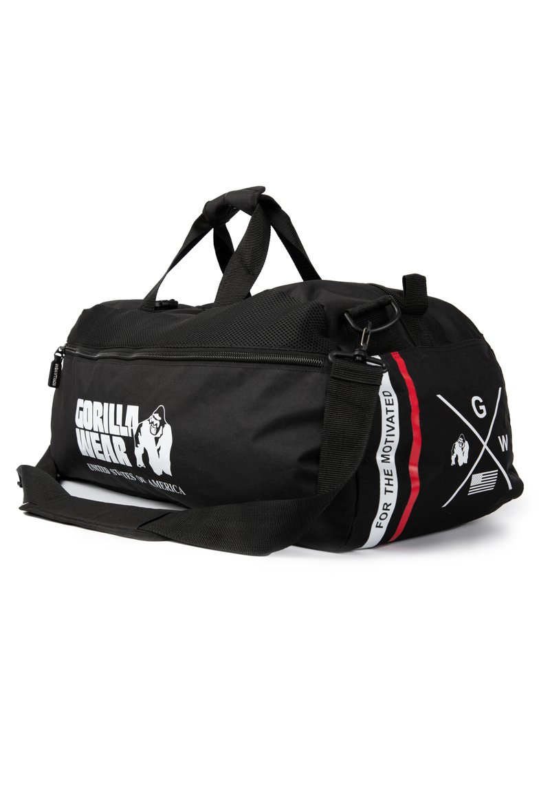 Black gym duffel bag made of durable fabric, featuring a zip closure, double handles, and a removable shoulder strap with logo and accents.