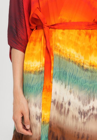 Abito multicolore con tessuto fluente dai toni arancione, rosso e verde. Include una cintura definita in vita e una superficie morbida e testurizzata.