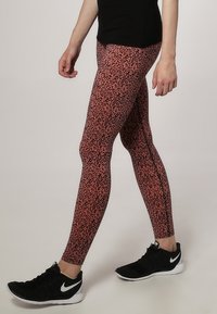 Skräddarsydda leggings i ett rosa och svart abstrakt mönster, tillverkade av elastiskt tyg, med en jämn yta och hög midja.