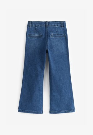 Plaši zili džinsi ar gludu tekstūru, ar klasisku piecu kabatu dizainu un redzamām šuvēm jostasvietā un apakšmalā.