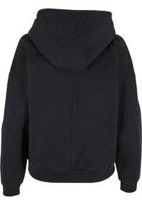 Sudadera negra de gran tamaño con una capucha grande, hombros caídos y puños y dobladillo acanalados, vista desde atrás.