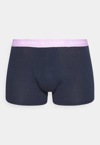 Boxers bleu marine avec une texture unie, présentant une taille élastique violet clair avec le logo "TOMMY HILFIGER".