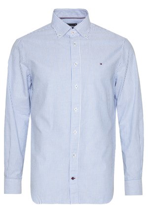 Herre langærmet skjorte med knapper, blå og hvide lodrette striber og et lille broderet logo på brystet.