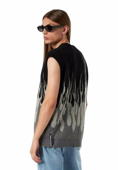 Maglione senza maniche in un motivo sfumato di nero e grigio a fiamma. Presenta un collo rotondo e orlo a coste. Indossato con jeans blu.