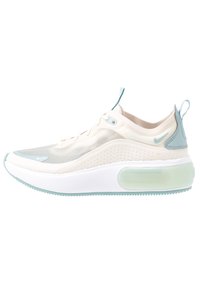 Ljusbeige och mintgrön Nike-sneaker med genomskinlig meshöverdel, tjock vit sula och dragflikar på plös och häl.