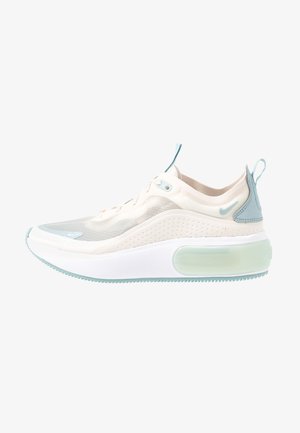 Baskets Nike de couleur beige clair et vert menthe avec une tige en mesh translucide, une épaisse semelle blanche et des languettes sur la languette et le talon.