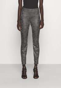 Grå fusk läderbyxor med en slät, matt yta, figursydd design, medelhög midja och smala ben, i kombination med svarta, snörda klackar.