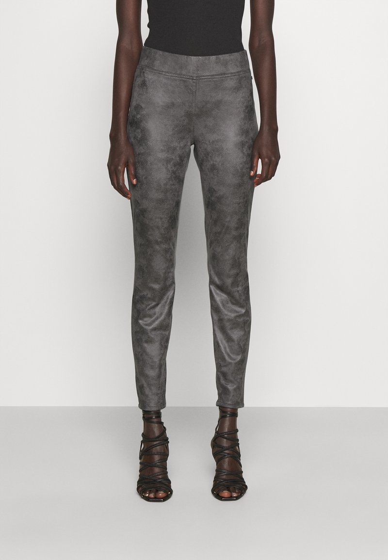 Grå fusk läderbyxor med en slät, matt yta, figursydd design, medelhög midja och smala ben, i kombination med svarta, snörda klackar.