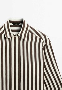 Chemise à manches longues avec col, rayée verticalement en brun et blanc, boutonnée en haut, fabriquée en tissu léger.