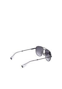 Lunettes de soleil aviateur en métal noir avec verres teintés foncés et branches transparentes sur fond blanc.