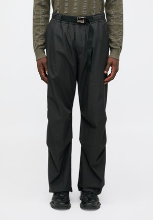 Čierne, ľahké cargo nohavice s elastickým pásom a predným opaskom. Majú bočné vrecká a hladký povrch. Vhodné na bežné nosenie.