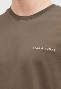 Λαδί βαμβακερό t-shirt με στρογγυλή λαιμόκοψη και κεντημένο λογότυπο "Lyle & Scott" σε λευκό στο αριστερό στήθος. Μαλακή υφή.