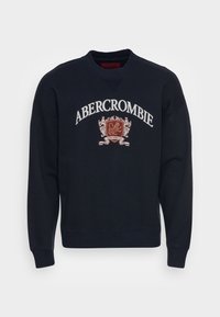 Námořnická modrá mikina vyrobená z bavlněné směsi s pružnými manžetami a lemem, s nápisem "ABERCROMBIE" a emblémem lva v červené a bílé barvě.