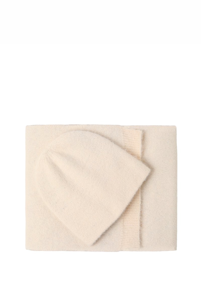 Das gestrickte, cremefarbene Set umfasst eine Mütze und einen passenden Schal, die über eine weiche Textur und ein einfaches, glattes Design verfügen.
