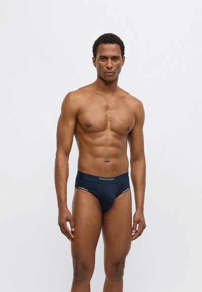 Tumši zili kokvilnas biksītes ar gludu tekstūru un elastīgu jostu ar baltu "Emporio Armani" zīmolu. Klasisks biksīšu dizains.