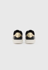 Black and gold sneakers with a smooth leather upper, rounded toe, and contrasting white rubber sole. Features a sleek design with a metallic accent.
