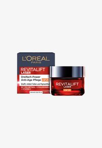 L'Oréal Revitalift Laser-kräm i en genomskinlig glasburk med silverlock, tillsammans med en blå och röd låda med produktinformation.