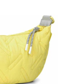 Borsa gialla trapuntata con forma arrotondata, dotata di cerniera grigia e dettagli texturizzati. Cordino di richiamo notevole con punte bianche.