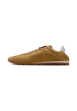 Zapato casual de ante marrón claro con suela blanca, lengüeta trasera blanca y cordones mixtos marrones y blancos, mostrado de lado sobre un fondo blanco.