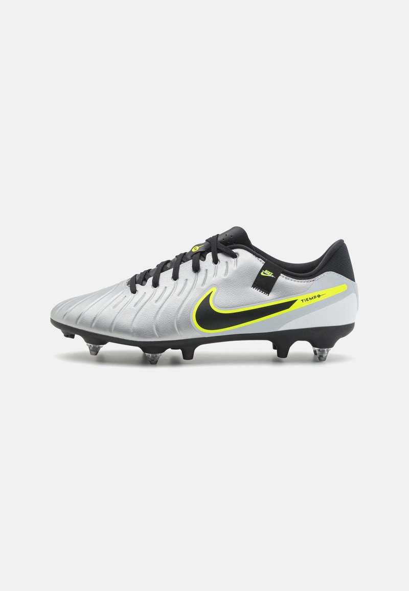 Botín de fútbol Nike Tiempo en plateado y negro con acentos en amarillo neón y cordones negros, mostrado de lado sobre un fondo blanco.