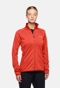 Giacca rossa con zip realizzata in tessuto texturizzato, con colletto alto, tasche laterali e dettaglio del logo sul petto. Ideale per attività all'aperto.