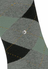 Calzino con motivo argyle grigio e verde con accenti neri, tessuto testurizzato, cuciture visibili in giallo e dettagli del logo argentato.