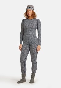 Full-body thermal suit in black and white pattern, made from stretchy, textured material. Includes matching knitted socks and beanie.