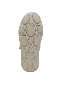 Semelle en caoutchouc beige avec un motif texturé ovale et circulaire, dotée de profondes rainures et d'un design en V central.