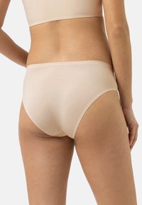 Slip in cotone nudo senza cuciture con una texture liscia, design a vita bassa e una fascia elastica minimale. La vista posteriore mostra un taglio base.