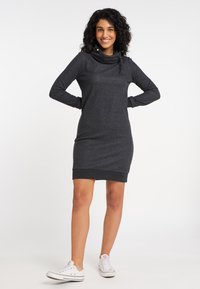 Tumehall sweatshirt-dress, millel on kühvelkaelus, pikad varrukad ja sooniline äär. Kombineeritud valgete tossudega, et saavutada lihtne välimus.
