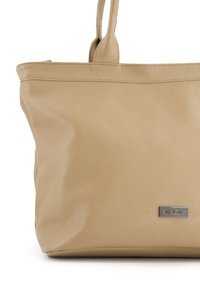 Beige kožená taška s texturovaným povrchem a dvojitými uchy. Na přední straně má malou stříbrnou logovou destičku s nápisem "VENEZIA".