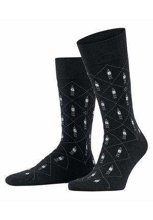 Black cotton socks featuring a diamond pattern with small white tower motifs. Smooth texture with ribbed cuffs for added grip.