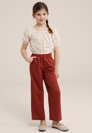 Top de manga abullonada a rayas blancas y naranjas combinado con pantalones de pierna ancha en color óxido, que cuentan con una cintura elástica y bolsillos laterales.