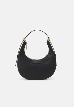 Sac à main en cuir noir en forme de croissant avec une petite bandoulière, fermeture éclair dorée, ferrure dorée et petit logo "Coccinelle" à l’avant.