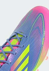 Blue and pink athletic shoe with a textured design, yellow accents, and a lace-up closure. Features a lightweight, flexible build.