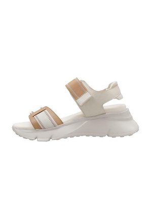 Sandalia deportiva blanca y beige con correas ajustables, suela acolchada y una suela texturizada para mayor agarre. Elementos de diseño minimalista.