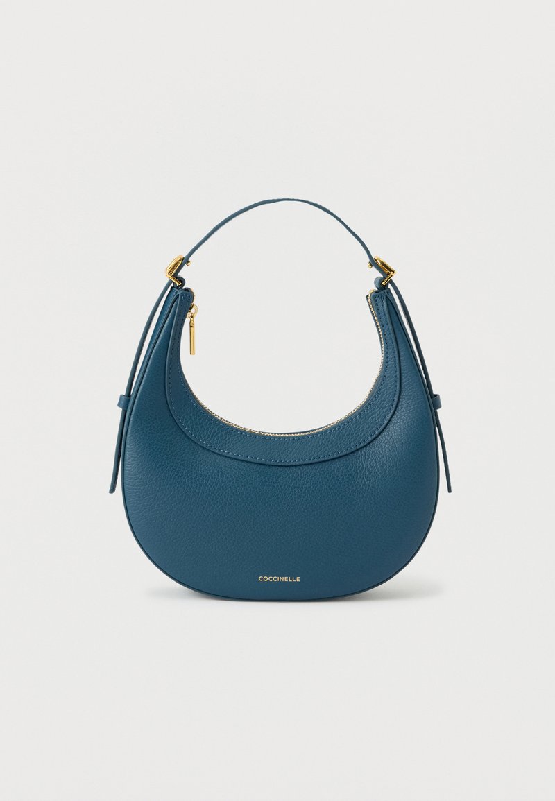 Mala de mão em couro azul com design curvo, detalhes em metal dourado, fecho de correr e alça curta para fácil transporte.