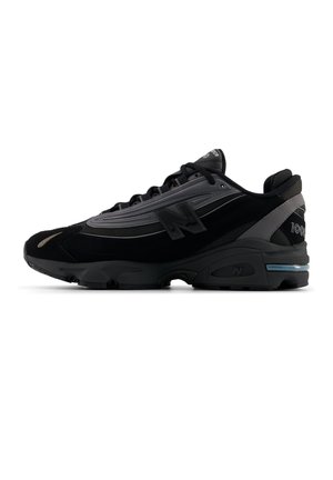 Baskets de sport noires et grises avec dessus en mesh et synthétique, fermeture à lacets, semelle amortissante et logos de la marque sur le côté et le talon.